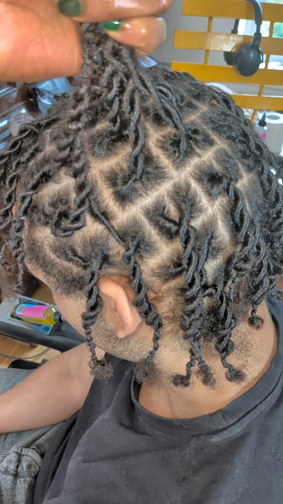 Two-strand starter twists hand-lift at the crown showing square grid parting